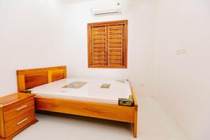a bedroom with a wooden bed and a window at BTLk D16- 27-02 in Thủy Triều +7 photos