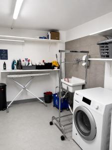 a laundry room with a washing machine and a sink at Chambre single à louer dans une colocation in Thyez