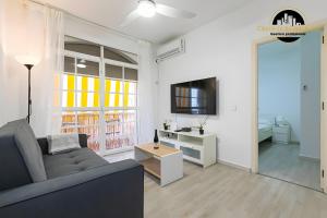 a living room with a couch and a tv at El Bajondillo Apartment in Torremolinos