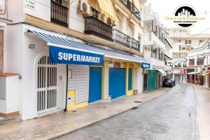 a street with blue and yellow doors on a building at El Bajondillo Apartment in Torremolinos