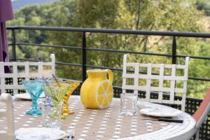 a table with a yellow vase and glasses on it at Les chaillées in Saint-Romain-en-Jarez +18 photos