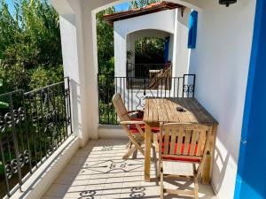 a porch with a wooden table and chairs on a balcony at Villa Nergis in Bitez