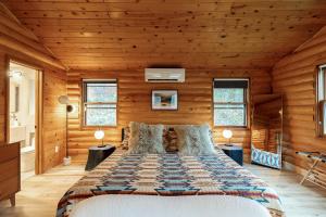 a bedroom with a bed in a room with wooden walls at Fawn Hill Elevated Log Cabin w Year-Round Pool in Phoenicia +57 photos