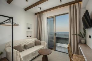 a living room with a white couch and a large window at Aiolos Suites in Rhodes Town