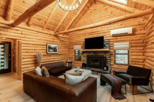 a living room with a couch and a fireplace in a log cabin at Fawn Hill Elevated Log Cabin w Year-Round Pool in Phoenicia