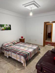 a bedroom with a bed and a couch at Appartement de luxe, Résidence les 5 étoiles, Bizerte in Zarzouna