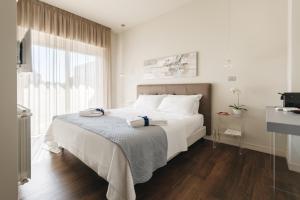 a white bedroom with a large bed and a window at I Segreti della Valle in Agrigento