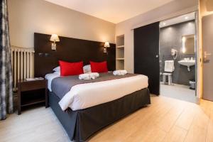 a bedroom with a large bed with red pillows at Hotel Migny Opéra Montmartre in Paris