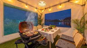 a tent with a grill and a table with food at Chuncheon El Dorado Kid's Pension in Gapyeong