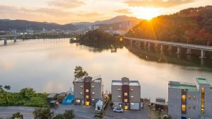 a view of a river with buildings and a bridge at Chuncheon El Dorado Kid's Pension in Gapyeong