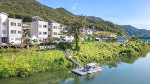 a boat is docked on a river next to buildings at Chuncheon El Dorado Kid's Pension in Gapyeong