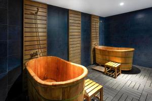 a bathroom with two wooden tubs and a bench at Hotel Sapa Square, Affiliated by Meliá in Sapa