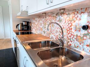 a stainless steel sink in a kitchen with floral wallpaper at Lakeview 4BR with Sauna & EV Parking in Åre