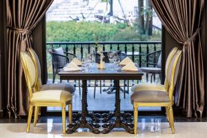 a table with wine glasses and chairs on a balcony at Hotel Sapa Square, Affiliated by Meliá in Sapa