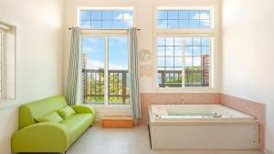 a bathroom with a green couch and a tub at Gangleung laimbichipensyeon in Gangneung