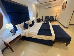 a large bedroom with a large bed and chairs at Hotel the Jeeven's in Sialkot