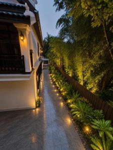 a garden with lights on the side of a house at Luang Prabang Indochine Heritage Hotel in Luang Prabang