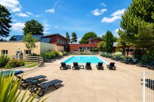 a pool with chaise lounge chairs and a swimming pool at L'EVIDENCE Love Room & spa in Chaveignes