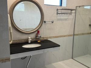 a bathroom with a sink and a mirror at Hotel the Jeeven's in Sialkot