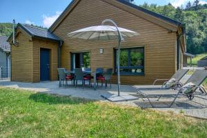 a patio with a table and chairs and an umbrella at Ferienhaus Immenhof in Rieden