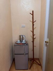 a small refrigerator with a tea pot and a cross at R&A Haven Guest House in San Juan