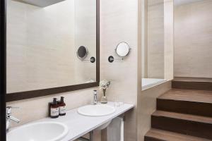 a bathroom with two sinks and a mirror at NH Ciudad de Santander in Santander