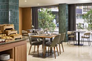 a dining room with tables and chairs and a window at NH Ciudad de Santander in Santander +27 photos