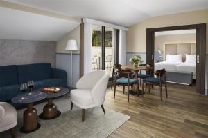 a living room with a couch and a bedroom at NH Ciudad de Santander in Santander