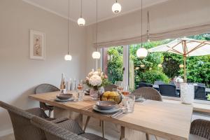 a dining room with a wooden table and chairs at Dolle's Hüs in Wenningstedt