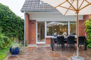 a patio with a table and chairs and an umbrella at Dolle's Hüs in Wenningstedt