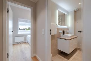 a bathroom with a sink and a mirror at Dolle's Hüs in Wenningstedt +43 photos
