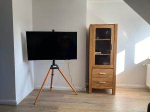 a television on a tripod in a room with a dresser at Ferienwohnung Strandkrabbe Ockholm in Ockholm