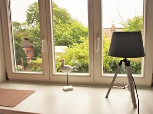 a bird standing on a tripod next to a window at Ferienwohnung Strandkrabbe Ockholm in Ockholm +7 photos