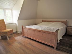a bedroom with a bed and a chair at Ferienwohnung Strandkrabbe Ockholm in Ockholm