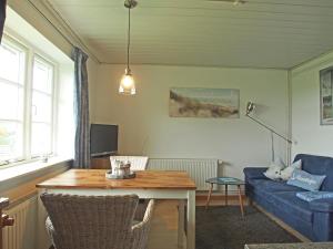 a living room with a table and a blue couch at Ferienwohnung Wattwurm Ockholm in Ockholm