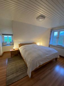 a bedroom with a large white bed and two windows at Ferienwohnung Wattwurm Ockholm in Ockholm
