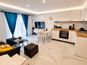 a kitchen and living room with a couch and a table at D4 Apartments Paralia No-5 in Paralia Katerinis