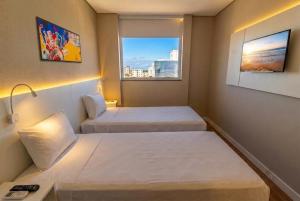 a hotel room with two beds and a window at Transamerica Fit Serra in Serra