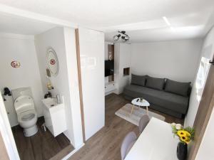 a small living room with a couch and a toilet at El Higo Apartments in Mostar +24 photos