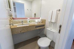 a bathroom with a toilet and a sink and a mirror at Transamerica Fit Serra in Serra
