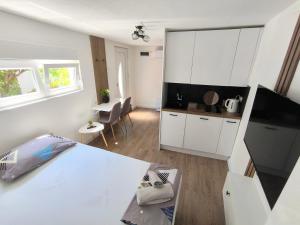 a white room with a kitchen and a white table at El Higo Apartments in Mostar