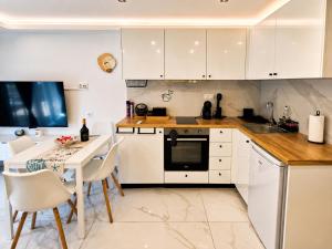 a kitchen with white cabinets and a table with chairs at D4 Apartments Paralia No-5 in Paralia Katerinis +7 photos