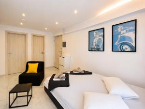 a bedroom with a large white bed and a chair at D4 Apartments Paralia No-5 in Paralia Katerinis