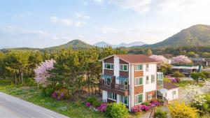 an aerial view of a house with mountains in the background at Goseong Omaju Pension in Goseong