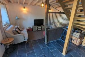 a living room with a couch and a television at 1 Bed Barn - Sleeps 2 - Pool - Garden - Bbq in Taunton