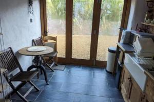 a kitchen with a table and chairs and a window at 1 Bed Barn - Sleeps 2 - Pool - Garden - Bbq in Taunton +7 photos