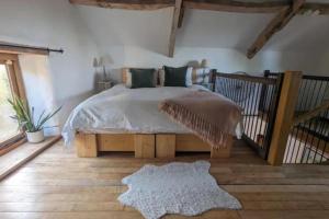 a bedroom with a large bed and a rug at 1 Bed Barn - Sleeps 2 - Pool - Garden - Bbq in Taunton