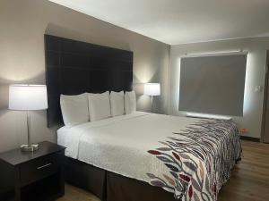 a bedroom with a large bed with a black headboard at Red Roof Inn Helen, GA - Downtown in Helen +18 photos