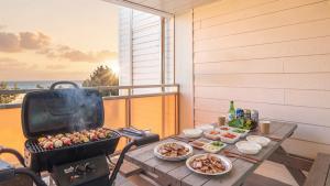 a grill on a table on a balcony with food at Yangyang Bono Pet-friendly Pension in Yangyang