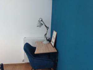 a desk with a lamp and a blue chair at Gosen appart in Athis-Mons +12 photos